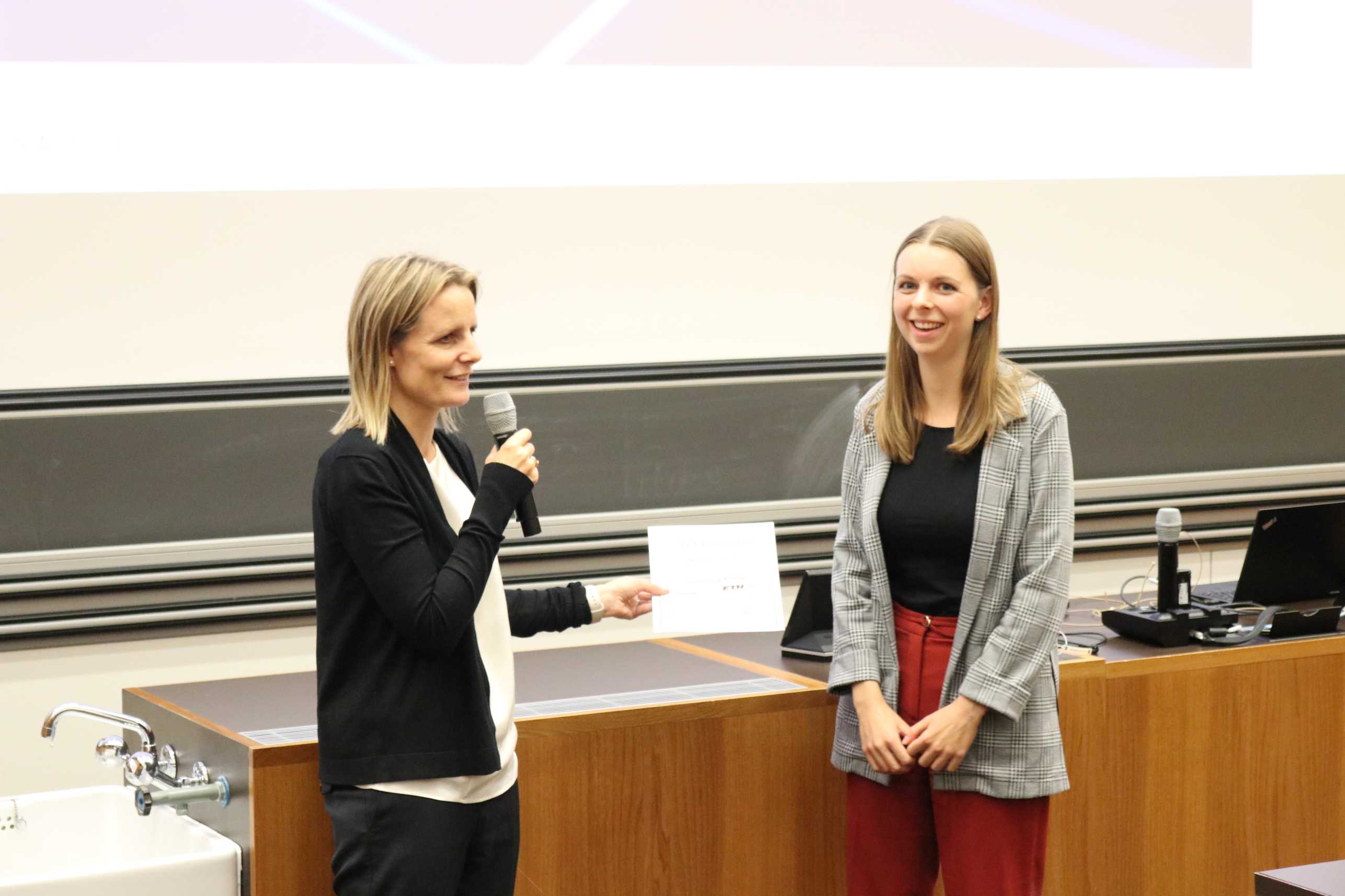 Olivia Champion von der Firma Helbling Beratung und Bauplanung AG überreicht den diesjährigen Helbing Preis an Nina Bichsel.